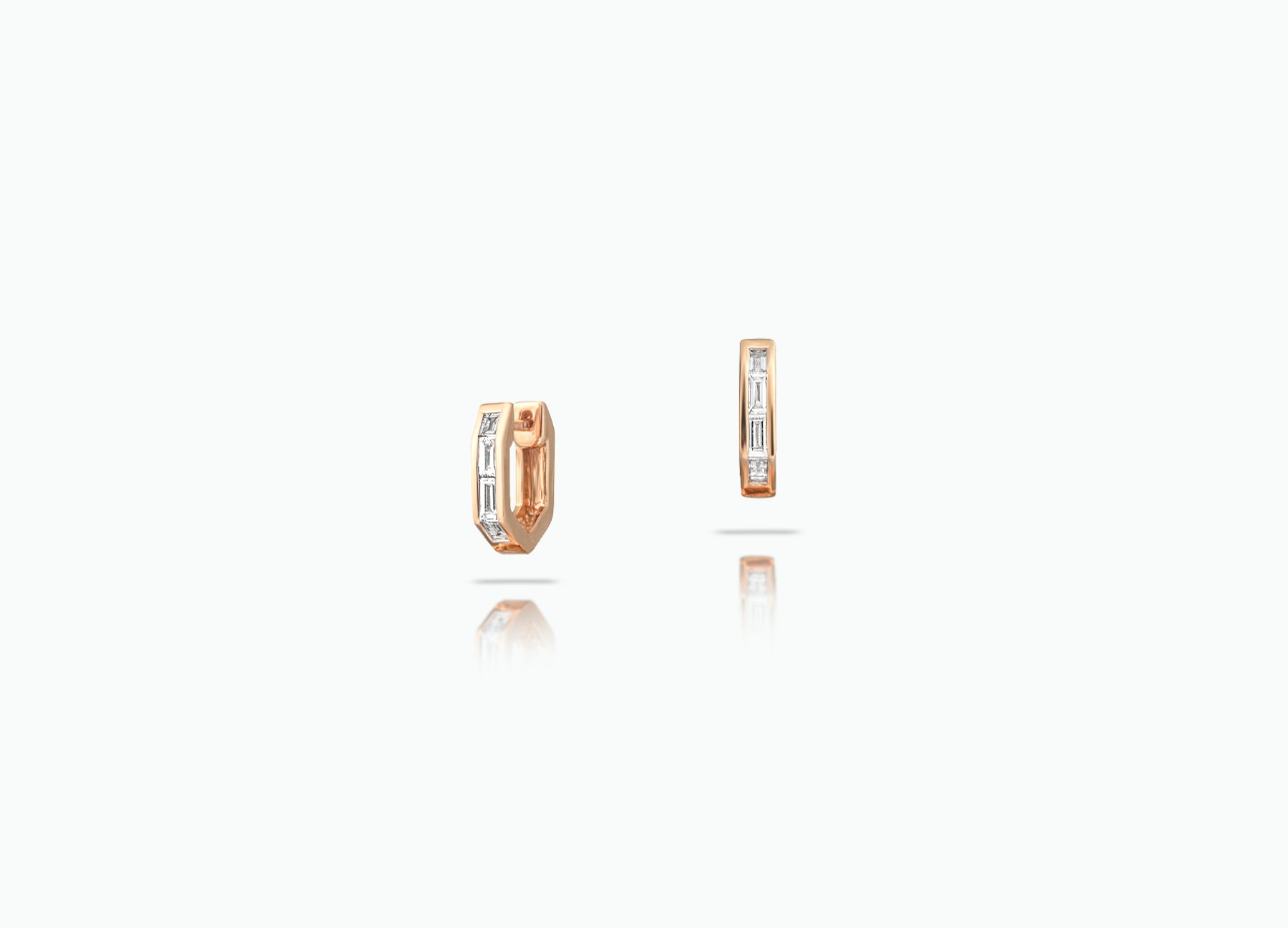 Huggie earrings made from rose, yellow or white 18k Gold. Each features a row of baguette-cut GVS white Diamonds.