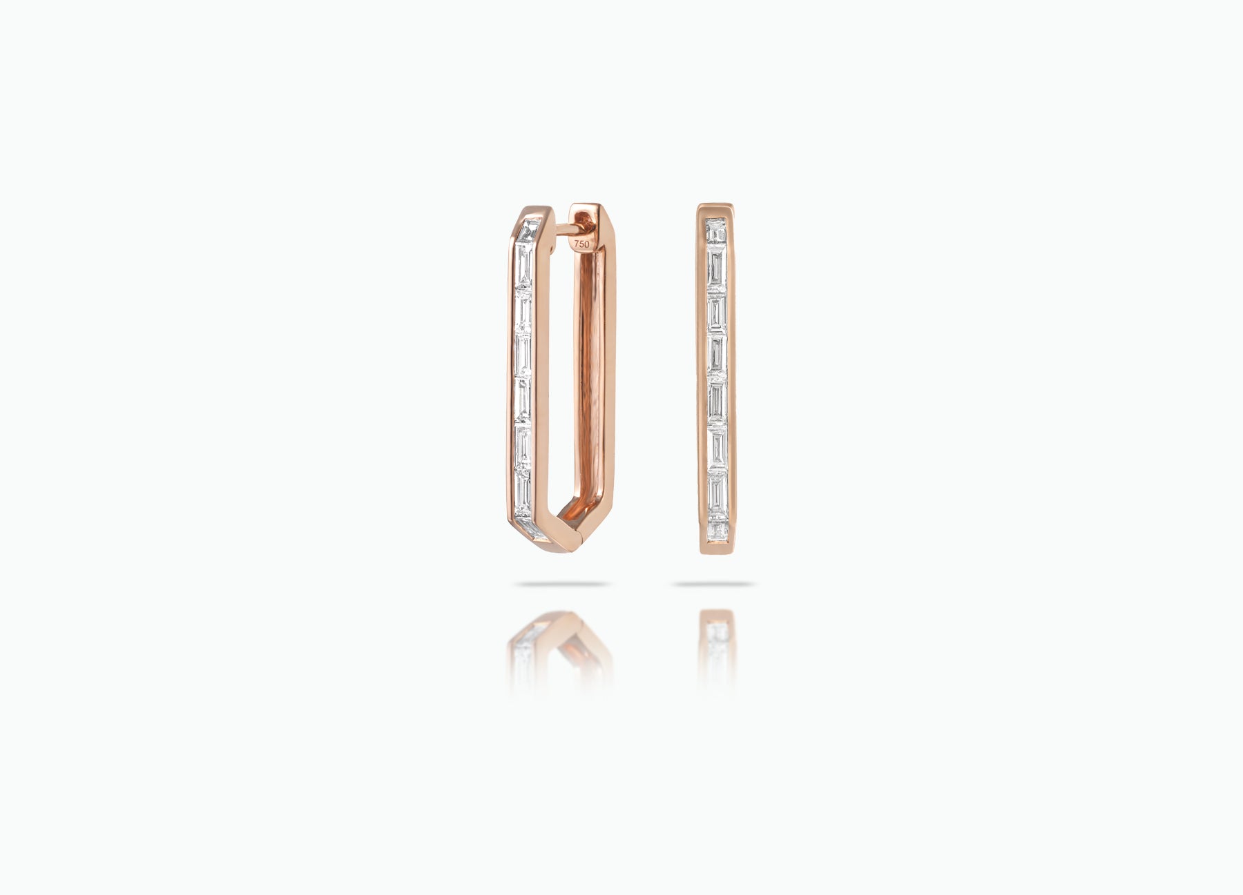 Elongated Huggie earrings made from rose, yellow or white 18k Gold. Each features a row of baguette-cut GVS white Diamonds.