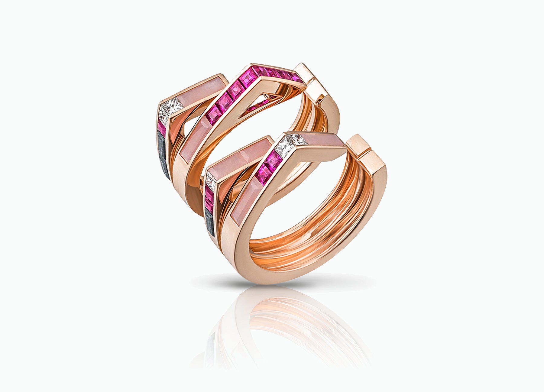 Stellar Pair of Stacking rings in 18K rose gold set with rubies and diamonds and pink opal by Tomasz Donocik Seen apart three quarter view